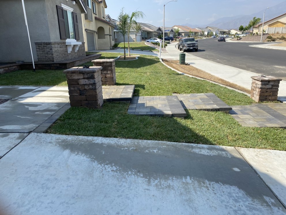 Landscaped home entry with curved concrete walkway and artificial turf