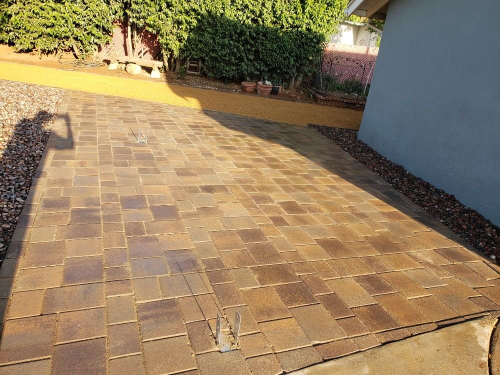Backyard patio installed with gray and tan pavers