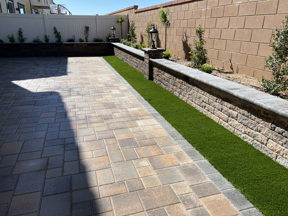 Paver patio beside a block retaining wall